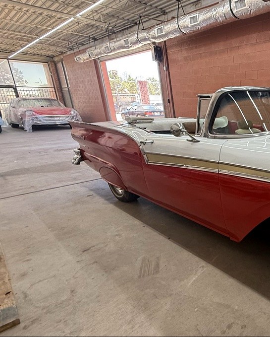 Red-and-white Ford Fairlane convertible, rear three-quarter view showing two-tone paint and tailfins