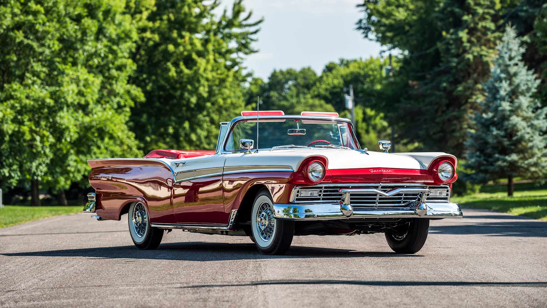 Red-and-white 1957 Ford Fairlane 500 Sunliner convertible with gold side sweep, front three-quarter view — same model shown for reference