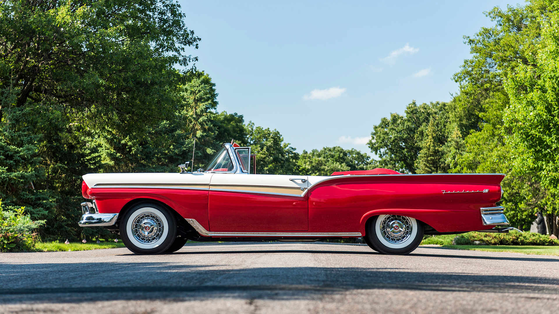 Red-and-white 1957 Ford Fairlane 500 Sunliner convertible in profile, white over red with gold side sweep — same model shown for reference